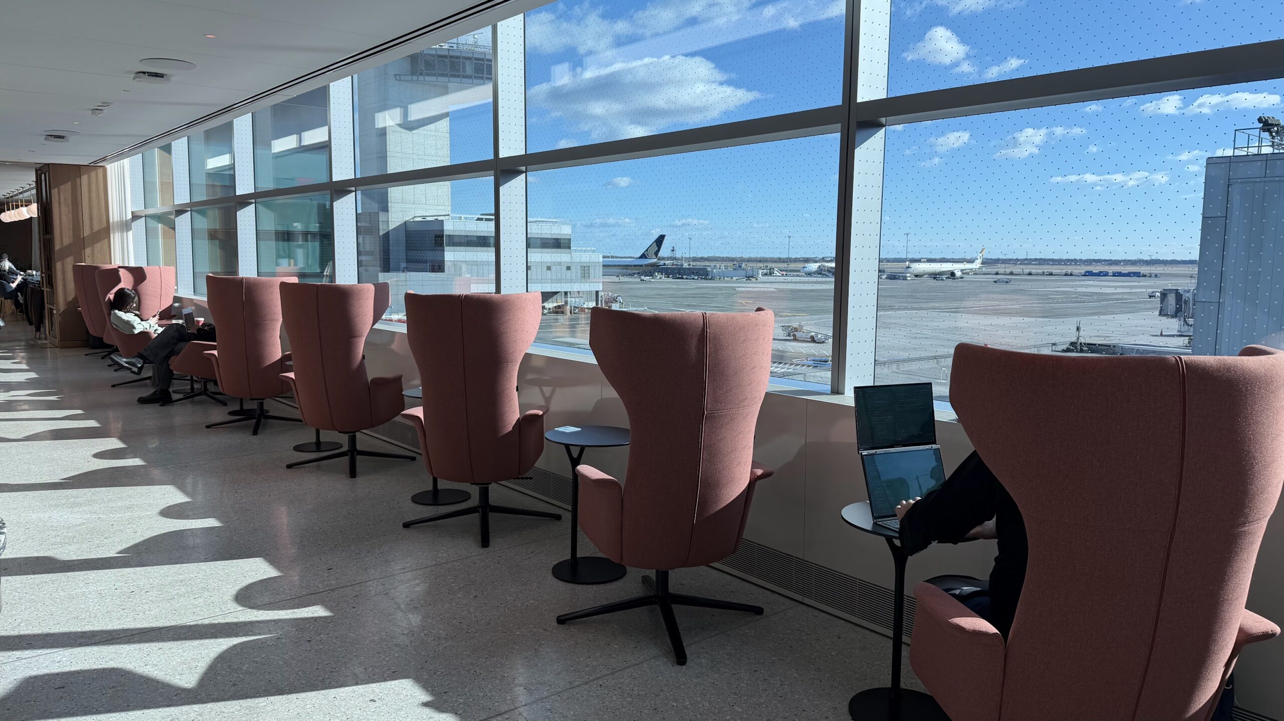 Lounge chairs lining up the walkway with tarmac views