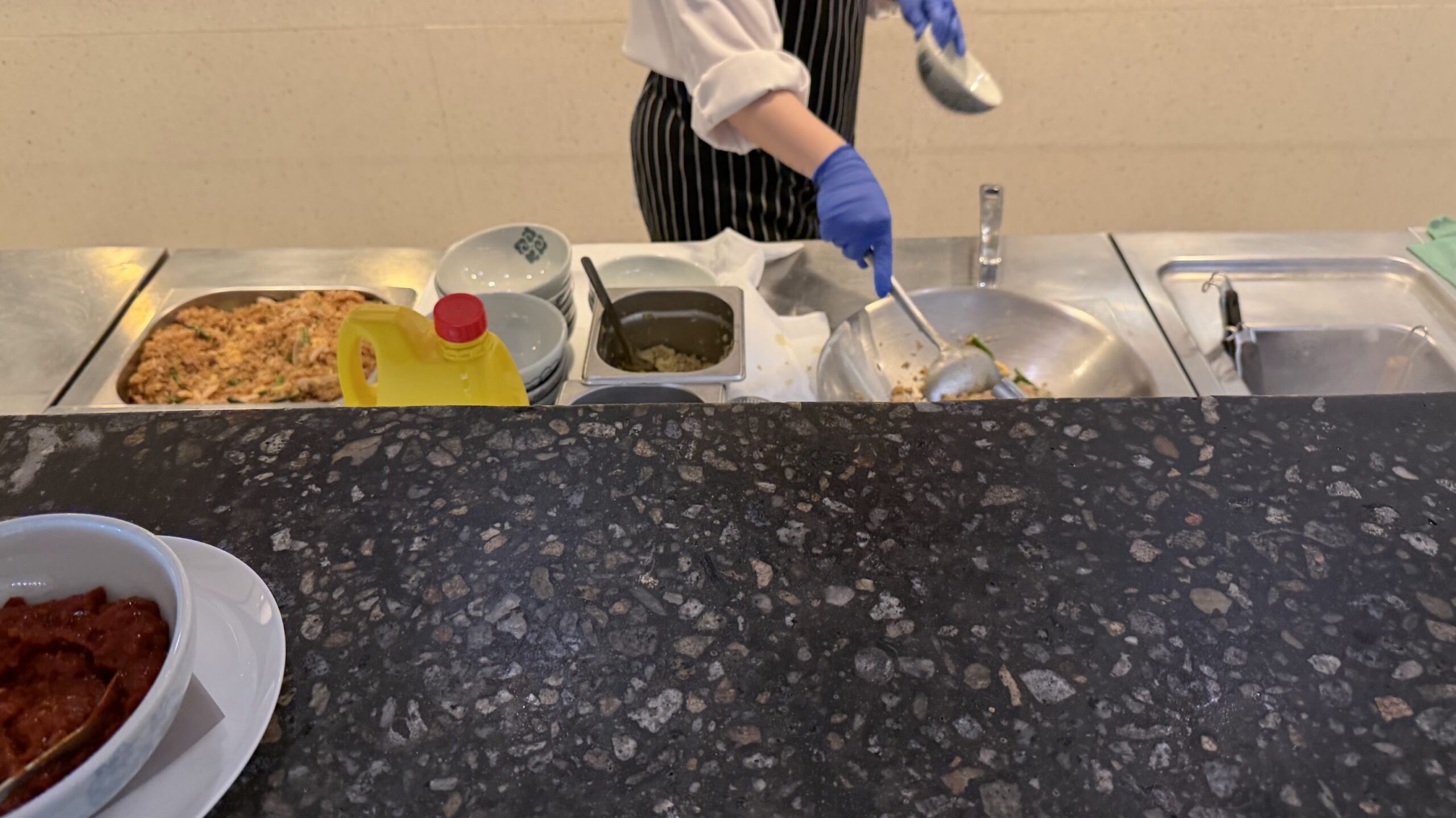 Chef preparing the made-to-order dishes at the Qantas Business Lounge Singapore