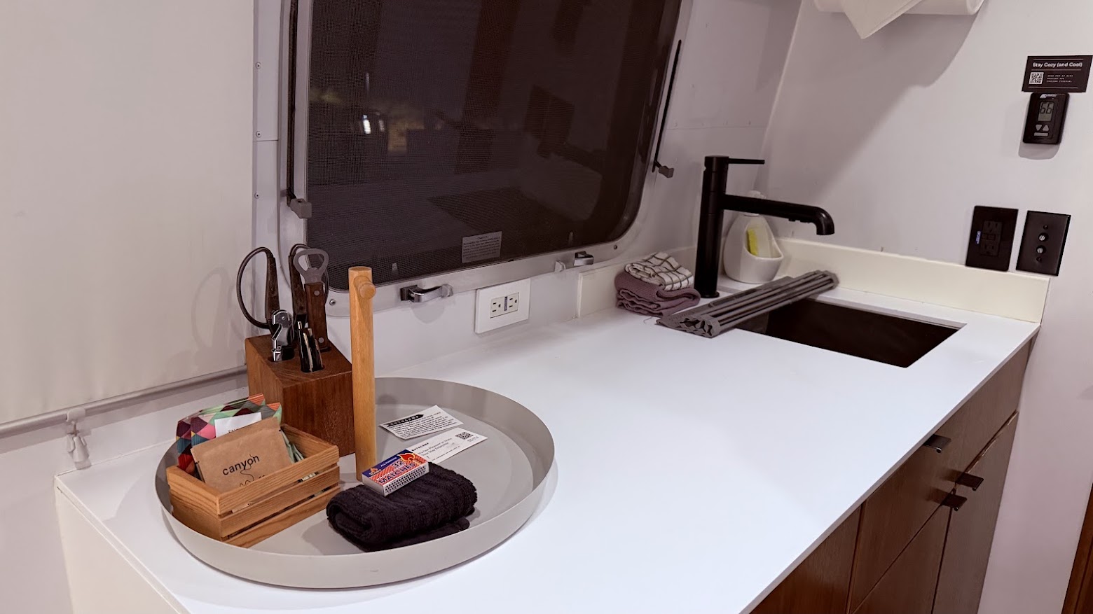Kitchen area with a small pantry containing coffee and tea, matchsticks, and some utility tools